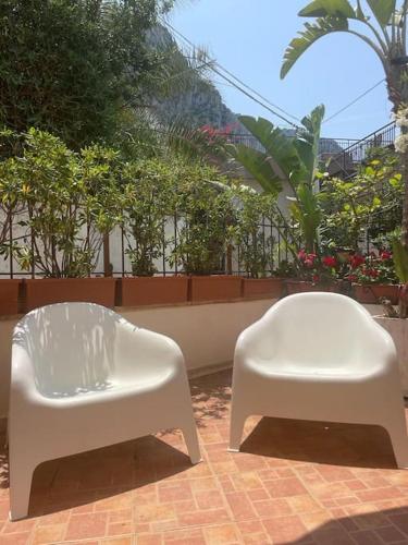 two white chairs sitting next to each other on a patio at La Scalinatella di Mondello in Palermo
