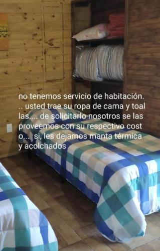 a bed with a blue and white blanket on it at Mozitas 33 in Barra del Chuy