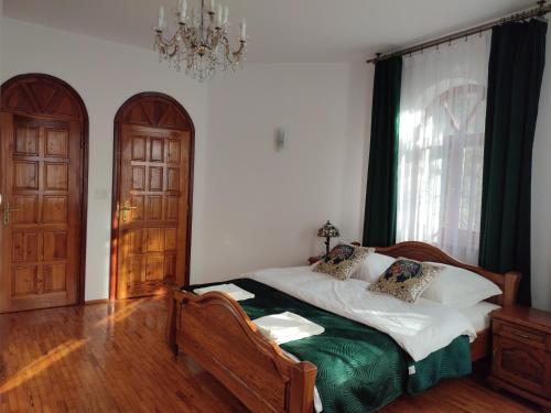 a bedroom with a bed and a chandelier at Willa Emil z BALIĄ ogrodową in Stróża