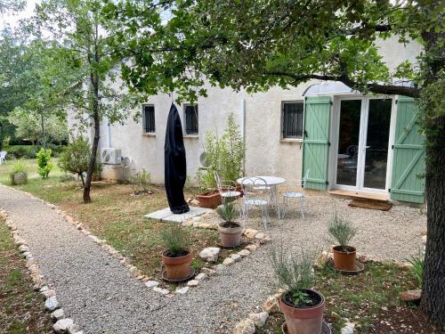 een tuin met een tafel en stoelen en een gebouw bij La Magistrale in Lorgues