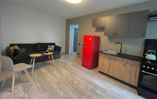 a kitchen with a couch and a red refrigerator at Lovely Stay in Siauliai in Šiauliai