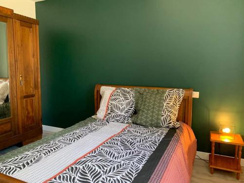 un lit dans une chambre avec un mur végétal dans l'établissement Appartement cœur de village Numéro2, à Peyriac-de-Mer