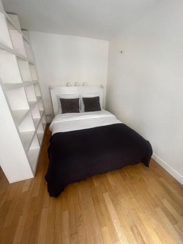 a bedroom with a bed with a black blanket at Your cosy Sacré-Coeur Apartment ! in Paris