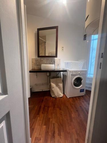 a bathroom with a washing machine and a mirror at Your cosy Sacré-Coeur Apartment ! in Paris