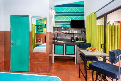 a room with a bed and a kitchen with a table at Tico Tico Villas - Adult Only in Manuel Antonio
