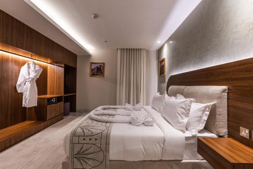 a bedroom with a large bed with white sheets at Tura Hotel in Riyadh