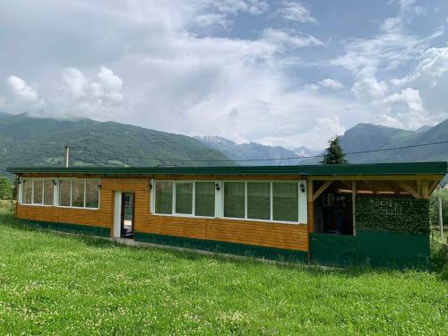 a house in a field with mountains in the background at Gusinje View in Gusinje