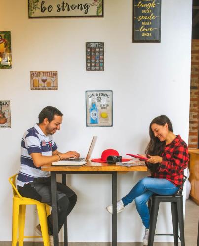 a man and woman sitting at a table with their laptops at Margarit Boutique Hotel in Mindo