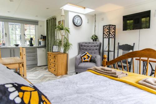 a bedroom with a bed and a kitchen at Cozy Garden Studio in Williton