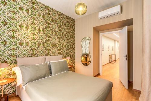 a bedroom with a bed and a wall with floral wallpaper at DOWNTOWN SRL - Croce di Malta Royale in La Spezia
