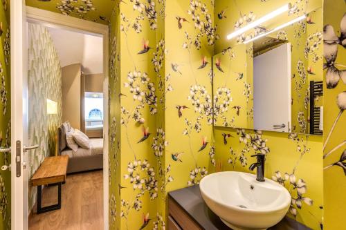 a yellow bathroom with a sink and a mirror at DOWNTOWN SRL - Croce di Malta Royale in La Spezia
