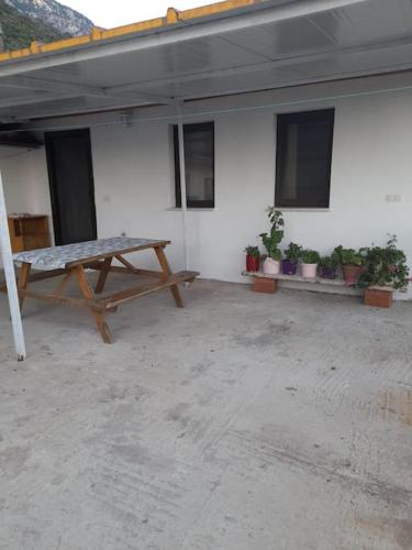 a picnic table in front of a building with potted plants at Akyaka Turnalı Kiralık Müstakil in Muğla