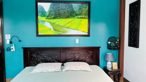 um quarto com uma cama com uma fotografia na parede em An Homestay-Super king size bed-Dunlopillo soft spring mattress-Vietnamese big breakfast em Ilha de Cát Bà