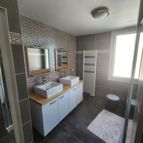 a bathroom with two sinks and a mirror at Magnifique logement spa in Pau