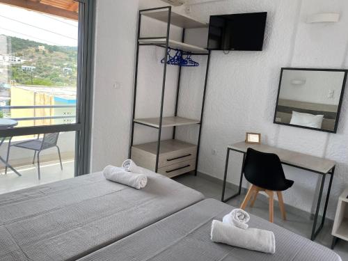 a bedroom with a bed and a desk and a television at Georgina in Agia Marina Aegina