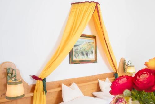 una camera da letto con un letto con specchio e fiori di Self-Check-in Hotel VinoQ Mistelbach a Mistelbach