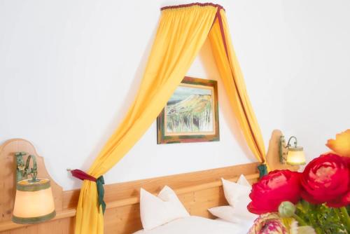 a bedroom with a bed with a mirror and flowers at Self-Check-in Hotel VinoQ Mistelbach in Mistelbach