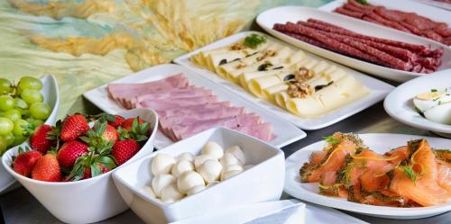 una mesa cubierta con platos de diferentes tipos de alimentos en Self-Check-in Hotel VinoQ Mistelbach, en Mistelbach