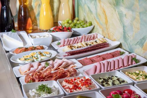 un buffet de diferentes tipos de comida en una mesa en Self-Check-in Hotel VinoQ Mistelbach, en Mistelbach
