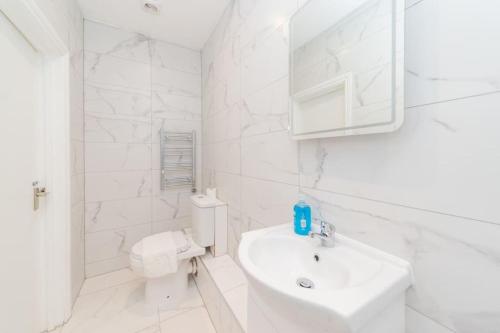 a white bathroom with a sink and a toilet at Super Central Studio Apartment I King Size Bed in Brighton & Hove