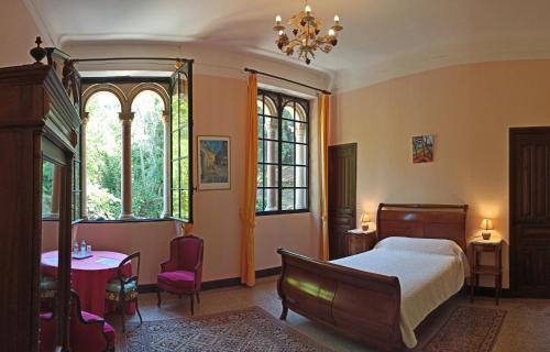 a bedroom with a bed and a table and chairs at CHÂTEAU CAGNINACCI B&B in San-Martino-di-Lota
