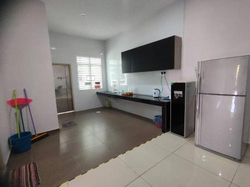 eine Küche mit einem Kühlschrank aus Edelstahl und einer Theke in der Unterkunft 20Pax 3-Storey SemiD 5Room&5Bathroom Sweet Dream Home Sitiawan in Sitiawan