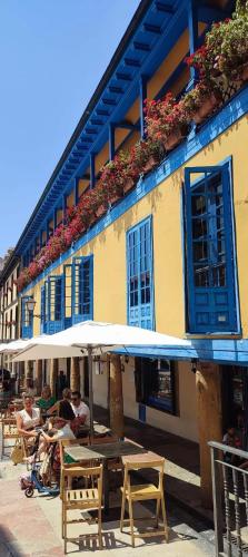 a group of people sitting under an umbrella in front of a building at Oviedo Centro- Parking gratuito in Oviedo