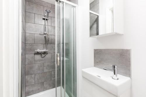 a bathroom with a sink and a shower at Hagley Road Apartments - Self Contained Entire Apartments with Kitchen & Netflix - Birmingham City Centre in Birmingham