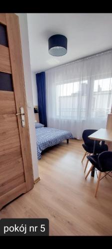 a bedroom with a bed and a table and chairs at Pokoje Gościnne Gąsowscy Dzieci od 12 roku życia in Międzyzdroje