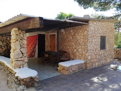 a stone house with a table and chairs outside at Villaggio La Roccia camping in Lampedusa