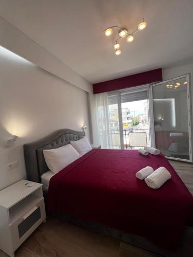 a bedroom with a red bed with two towels on it at ARBI VENICE STATiON in Mestre