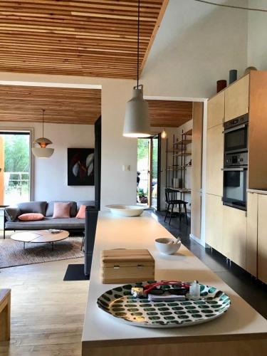 une cuisine et un salon avec un canapé et une table dans l'établissement Maison Chalet design Briançon Serre Chevalier, à Puy-Saint-André