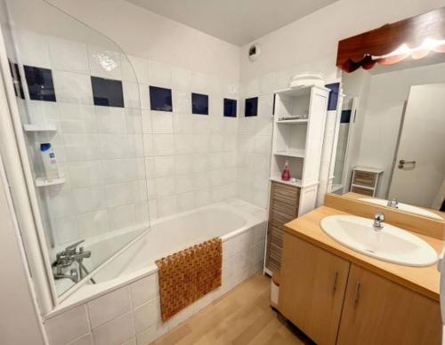 y baño con bañera blanca y lavamanos. en GUZET-Pyrénées-Pied des pistes, en Ustou