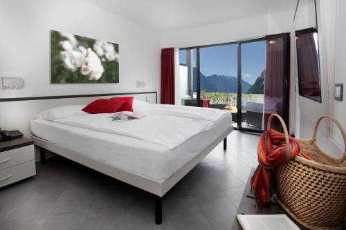 a bedroom with a large bed and a large window at Agritur Acetaia Gourmet&Relax in Tenno