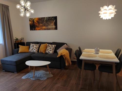 ein Wohnzimmer mit einem Sofa und einem Tisch in der Unterkunft Nový apartmán v klidu Jizerek in Smržovka