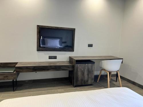 a desk with a television and a chair in a room at Mod Avenue in Gurgaon