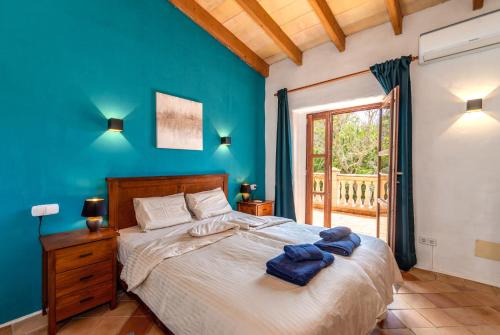 ein Schlafzimmer mit einem großen Bett mit blauen Wänden in der Unterkunft Borgata Roggio in Sineu