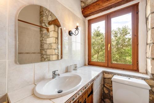 een badkamer met een wastafel, een spiegel en een toilet bij Borgata Roggio in Sineu