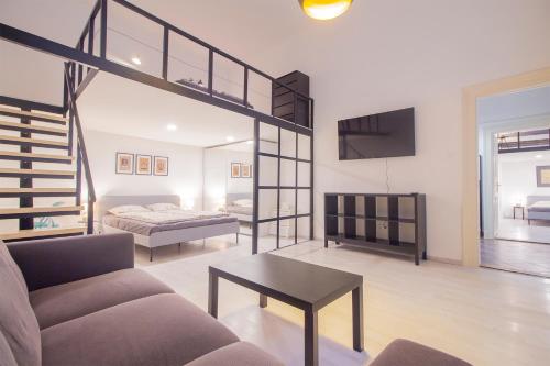 sala de estar con sofá, cama y escalera en Industrial Double Loft Apartment, en Budapest