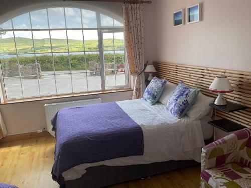 a bedroom with a bed and a large window at Brownes in Dingle