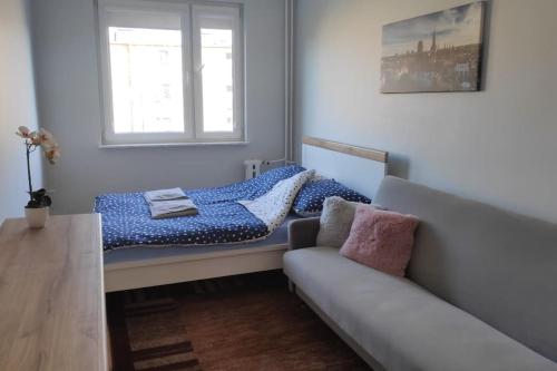 1 dormitorio pequeño con 1 cama y 1 sofá en Środek Trójmiasta, en Gdansk