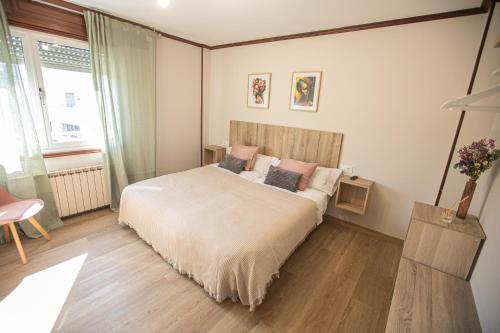 a bedroom with a large bed with pillows on it at Pensión Lobre in O Pedrouzo