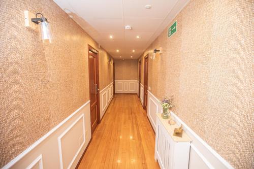 a hallway with a long corridor with wood floors and walls at Pensión Lobre in O Pedrouzo