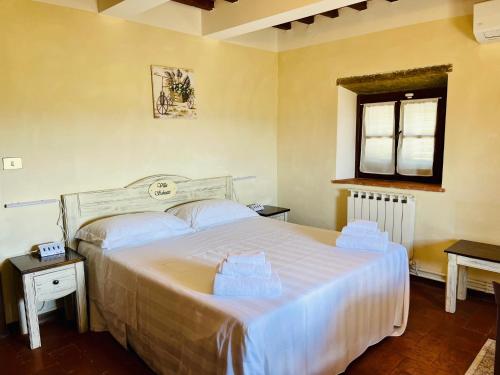 a bedroom with a large white bed and a window at Villa Schiatti in Cortona