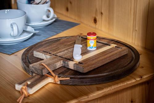 een houten tafel met een houten snijplank met een pot erop bij Haus BergGesundZeit Doppelzimmer Kärlingerhaus in Schönau am Königssee