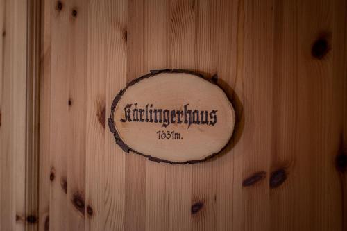een houten muur met een bord erop bij Haus BergGesundZeit Doppelzimmer Kärlingerhaus in Schönau am Königssee
