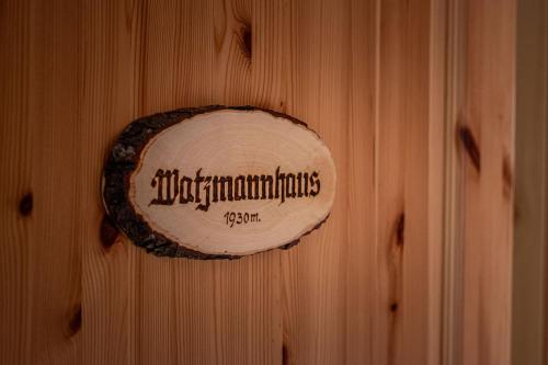 una pared de madera con un cartel. en Haus BergGesundZeit Doppelzimmer Watzmannhaus en Schönau am Königssee