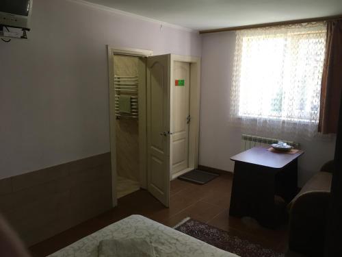 a bathroom with a shower and a door with a table at Номер та Паркінг- Світло Є in Chernivtsi