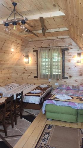 um quarto com 2 camas num chalé de madeira em Cottage Bosaca em Žabljak