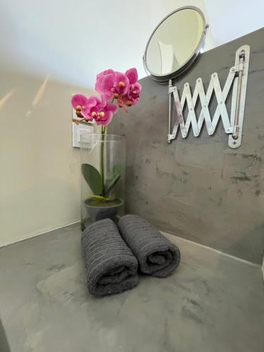 La salle de bains est pourvue d'un vase de fleurs et d'un miroir. dans l'établissement Luxury Villa set in Idyllic Cove, sunets, dolphins Nr Lefkada Villa Levanda, à Spartos